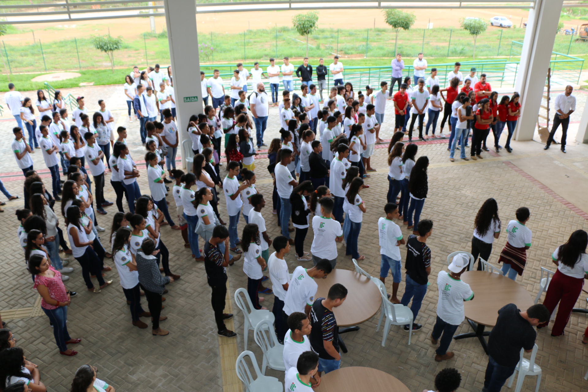 Servidores e alunos em momento de minuto de silêncio em homenagem às vítimas da Escola Estadual Raul Brasil.